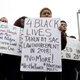 Chloe Compton, center, joins dozens of others in a demonstration outside the Sacramento Police Department to protest the decision to not prosecute the two officers involved in the 2018 fatal shooting of Stephon Clark, in Sacramento, Calif., March 2, 2019.